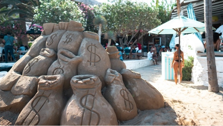 Μύκονος: Τσουβάλια από άμμο με σήμα το δολάριο - Το εντυπωσιακό έργο του Alec Monopoly στη Ψαρρού